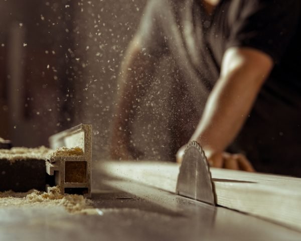 A man cuts wood on a circular saw in a joinery.